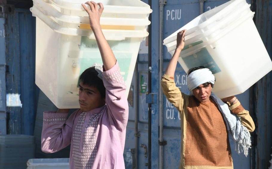 Boys at an election office in Kandahar help load trucks with ballot boxes on Friday, Oct. 26, 2018. The boxes will be dispersed at local polling centers ahead of voting on Oct. 27.