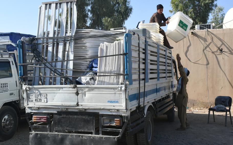 Boys at an election commission office in Kandahar help load trucks with ballot boxes on Friday, Oct. 26, 2018. The boxes will be dispersed at local polling centers ahead of voting on Oct. 27.