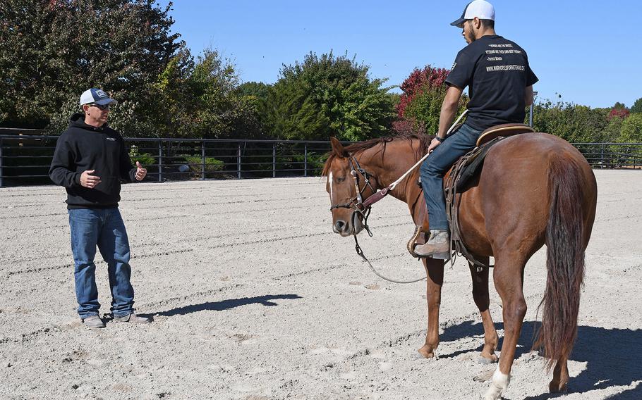 Patrick Benson, co-founder and director of War Horses for Veterans, explains the importance of relaxing and breathing when you ride, to a combat veteran during the nonprofit's October program.