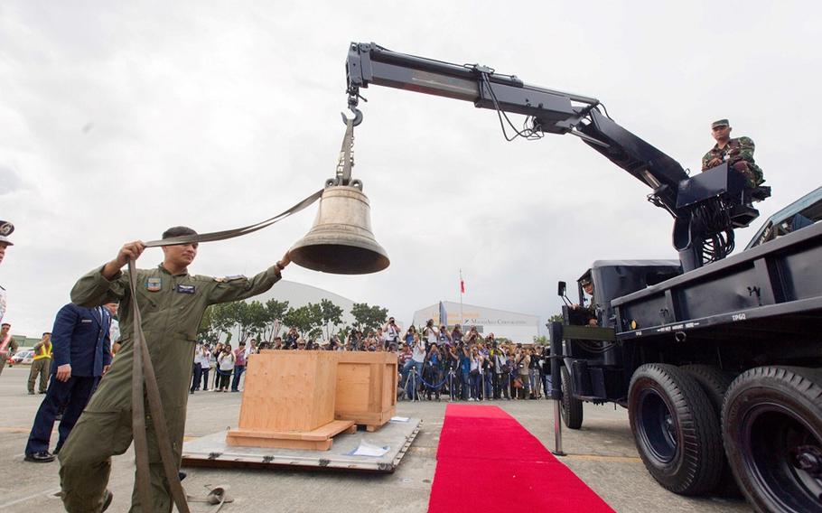 One of the Balangiga Bells is removed from its crate before a ceremony honoring the bells' return at Villamor Air Base, Philippines, Tuesday, Dec. 11, 2018.