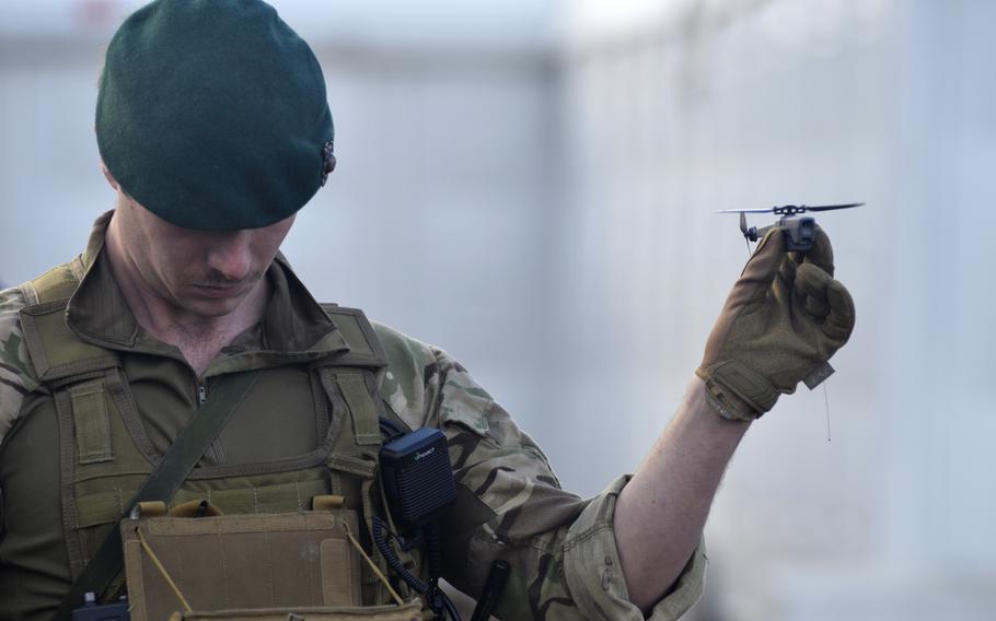 A British Royal Marine readies a FLIR Black Hornet drone for demonstration during Exercise Autonomous Warrior on the Salisbury Plain Training Area, England, Monday, Dec. 10, 2018. The nearly silent, pocket-sized drone transmits live video and high-definition images back to the operator and can fly about a mile in up to 25 minutes of flight time.