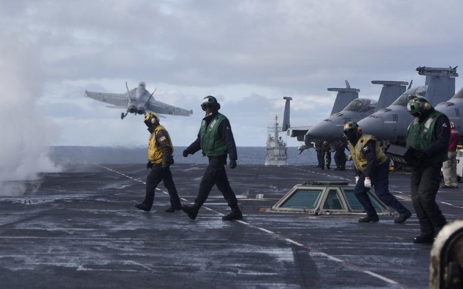 Sailors stand on the flight deck after launching an F/A-18F Super Hornet of Strike Fighter Squadron 211 aboard the aircraft carrier USS Harry S. Truman in the North Atlantic, Sept. 18, 2018.