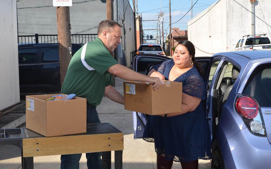John Valentine, CEO and founder of Operation Phantom Support, hands a box of food items to Lilia Van Dyke, a runner with JoyRun, outside the nonprofit???s food pantry in Killeen, Texas on Dec. 13. The nonprofit and the smartphone app have partnered together to deliver items from the food pantry to those in need.
