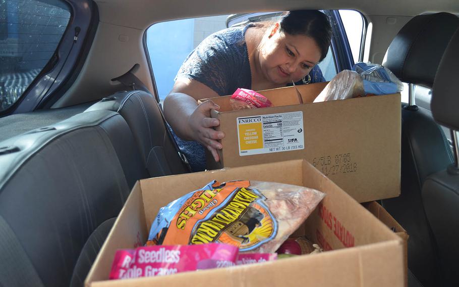 Lilia Van Dyke, a runner for the smartphone app JoyRun, places a box from the Operation Phantom Support food pantry into her car in Killeen, Texas on Dec. 13.