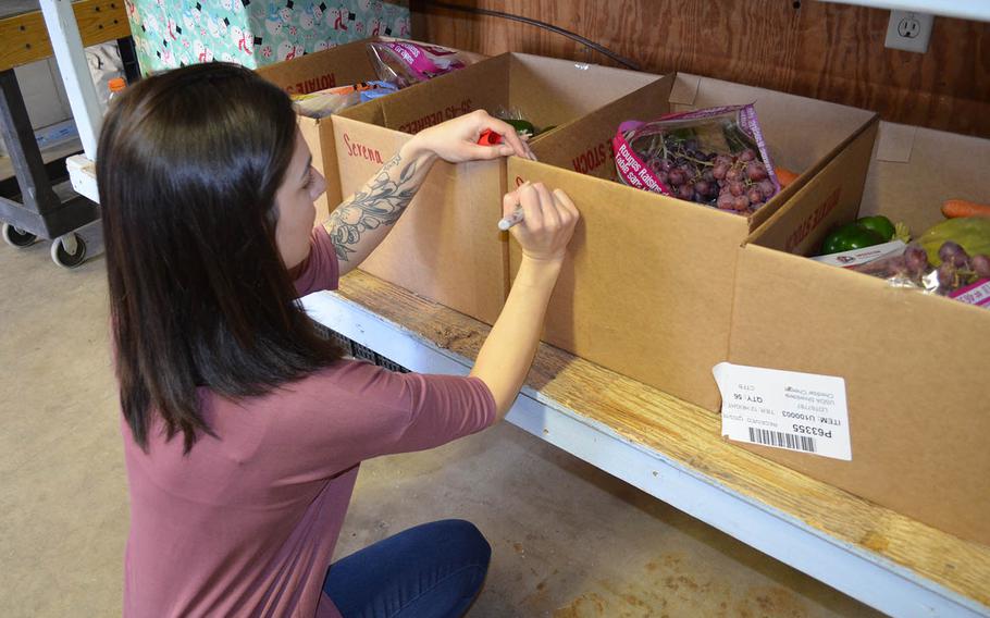 Julia Erb, Killeen runner community manager for JoyRun, preps boxes of food for delivery at Operation Phantom Support???s food pantry in Killeen, Texas on Dec. 13.
