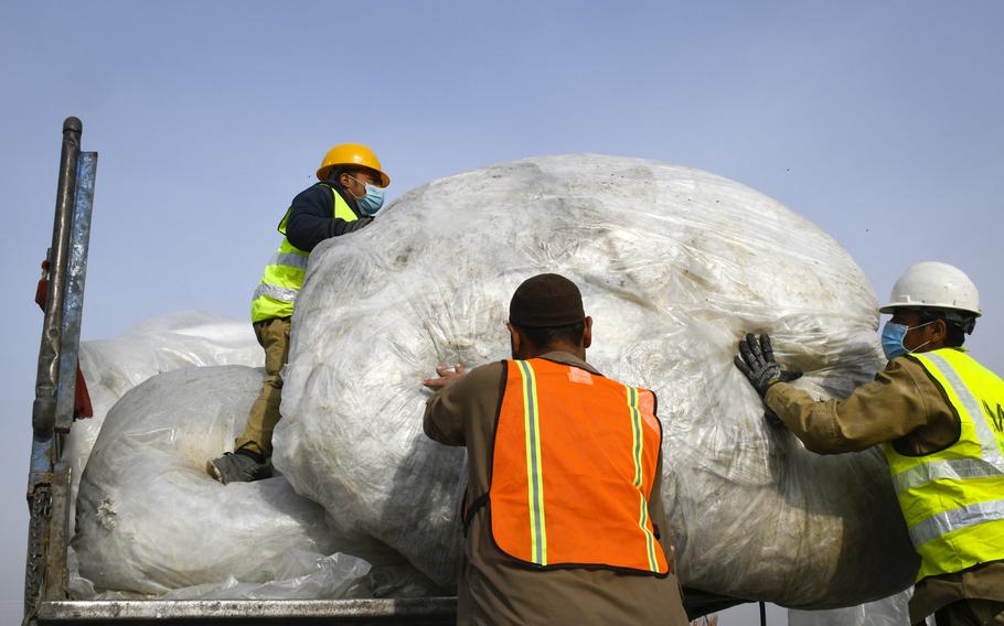 Afghan workers gather plastic bags recycled from the nearby Bagram Air Field.