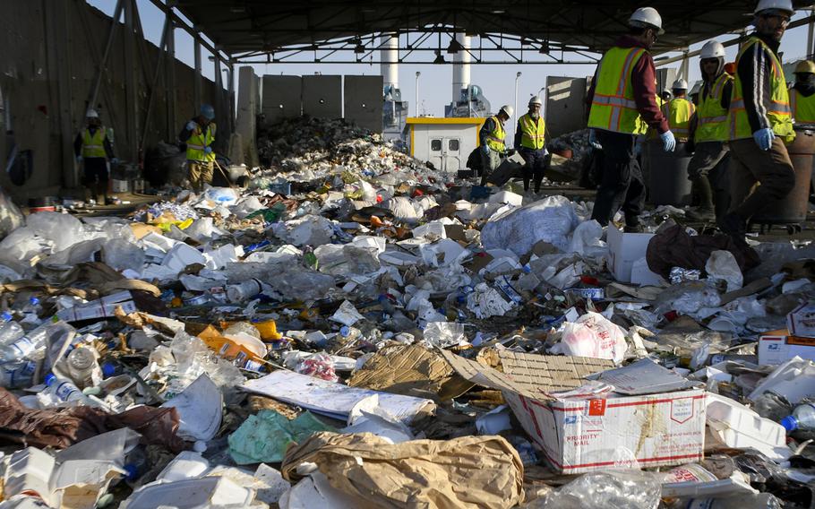 Local workers pick through the tons of garbage thrown out daily by personnel at Bagram Air Field. Around half of the daily garbage at the base is burned and half is given to contractors outside the base who recycle and sell the trash.