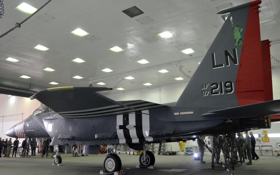 An F-15E Strike Eagle from the 492nd Fighter Squadron painted in a new World War II-inspired design to commemorate the D-Day 75th Anniversary, at RAF Lakenheath, England waits in a hangar, Thursday, Jan. 31, 2019. The heritage fighter jet is painted with the checkered pattern on the nose, black stripes down the wings, national insignias and a Statue of Liberty on each tail.