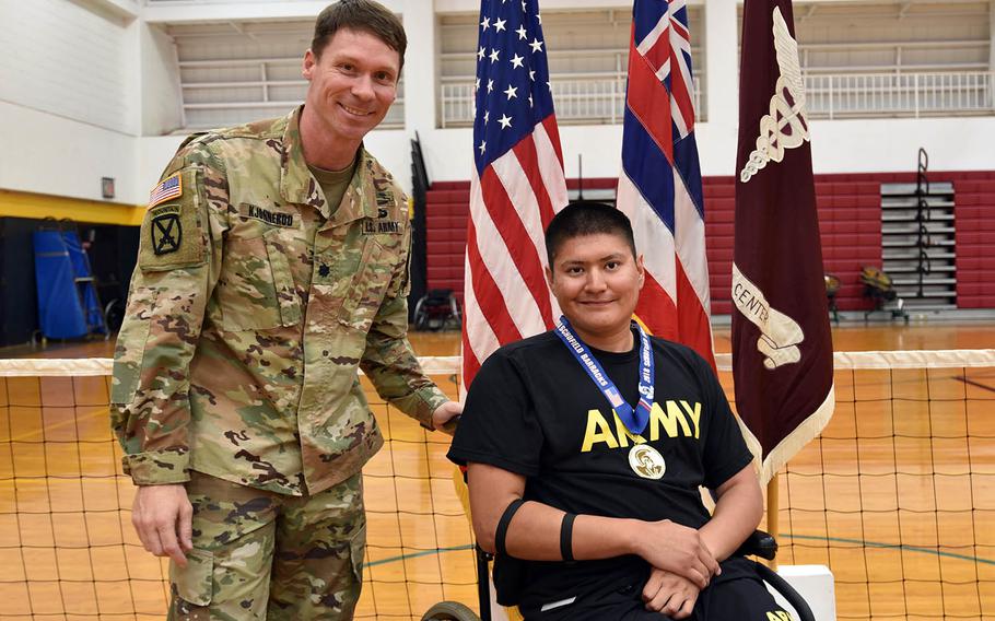 Spc. Kevin Holyan, a wounded warrior athlete from the Fort Sam Houston Warrior Transition Battalion, poses with Lt. Col. Eric Kjonnerod, commander of Warrior Transition Battalion-Hawaii, during the 2018 Pacific Regional Trials indoor rowing medal ceremony at Schofield Barracks, Hawaii, Nov. 10, 2018.