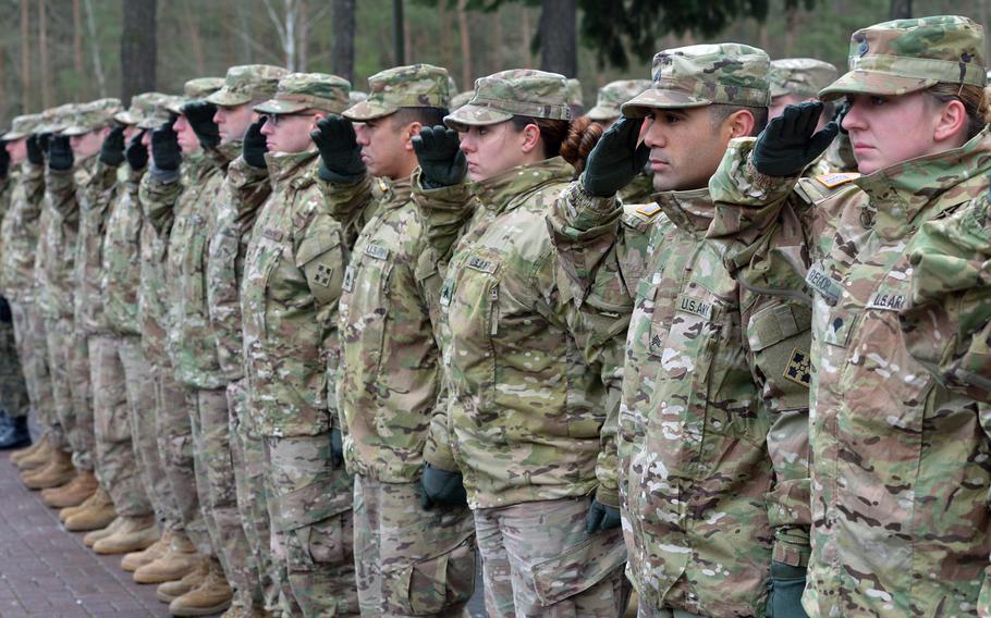 American rotational soldiers of the 4th Infantry Division salute during the national anthem at a welcoming ceremony for them in Zagan, Poland. The U.S.plans to deploy more troops to Poland, the U.S. ambassador to the country, Georgette Mosbacher, said Wednesday.