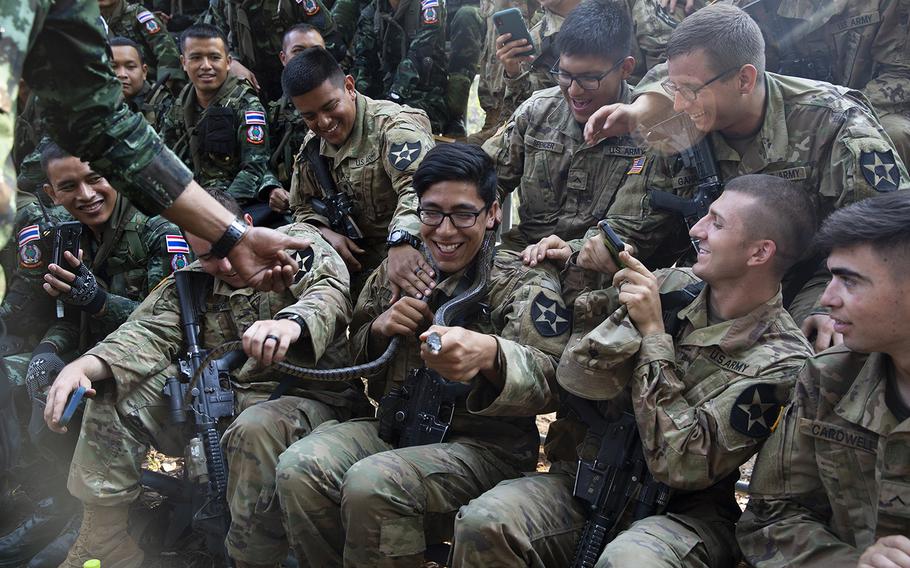 U.S. Army Spc. James S. Teaney with Bravo Company, 5th Battalion, 20th Infantry Regiment, holds a snake during exercise Cobra Gold 19 at Phitsanulok, Thailand, on Feb. 13, 2019.