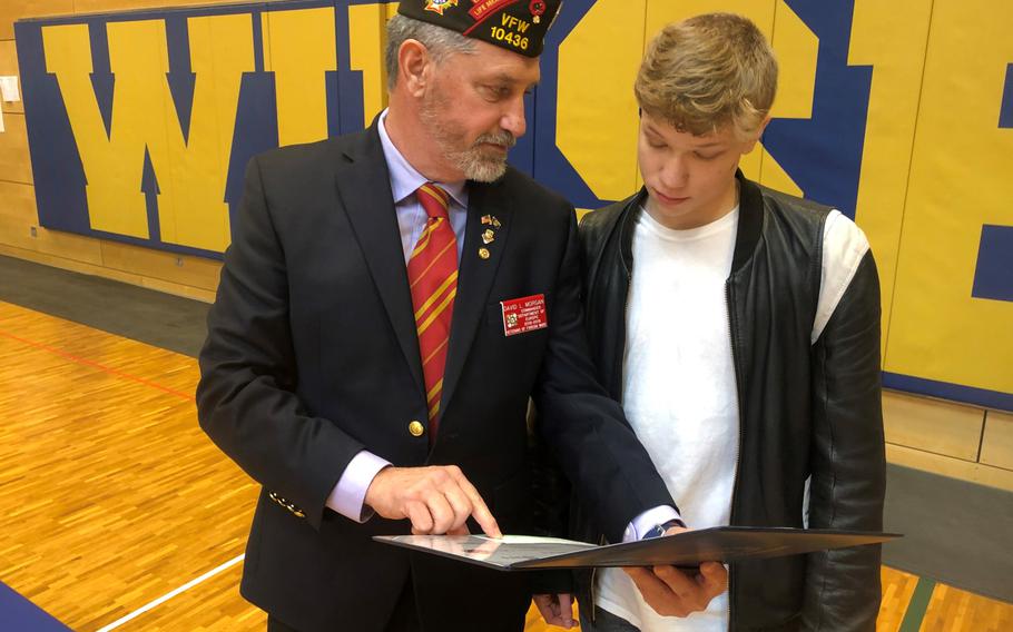 David Morgan, the European district commander for the Veterans of Foreign Wars, awards Eoin Oravetz, a senior at Wiesbaden High School, scholarship checks and certificates on behalf of the VFW at Hainerberg Kaserne, Feb. 14, 2019.