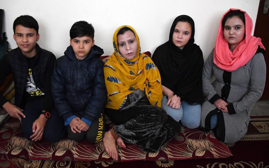 Nasima, who like many Afghans uses just one name, sits with her children in their apartment in northern Kabul on Monday, Feb. 4, 2019.