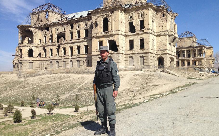 A police officer guards the main driveway to Kabul's bombed-out Darul Aman Palace in 2016. Reconstruction work on the complex, destroyed in fighting between rival warlords in the 1990s, has begun. Many Afghans fear civil war could breakout in their country again if international forces withdraw hastily.