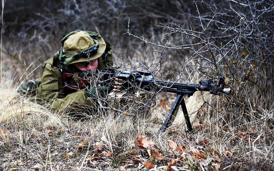 A Georgian soldier playing as the opposition force takes aim with an RPK machine gun during training at the Georgia Defense Readiness Program, in Tbilisi, Georgia, Wednesday, Feb. 20, 2019. 
