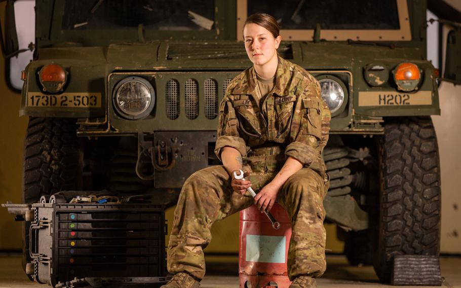Spc. Kendra Lay, a wheeled-vehicle mechanic with the 173rd Airborne Brigade, poses in front of a vehicle for a photo exhibition of military women in Vicenza.
