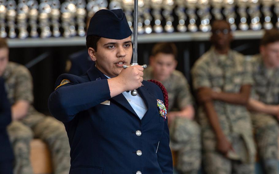 Natalie Toney salutes as she competes in the dual saber exhibition during the DODEA-Europe JROTC drill team championships at Ramstein, Germany, Saturday, March 2, 2019.