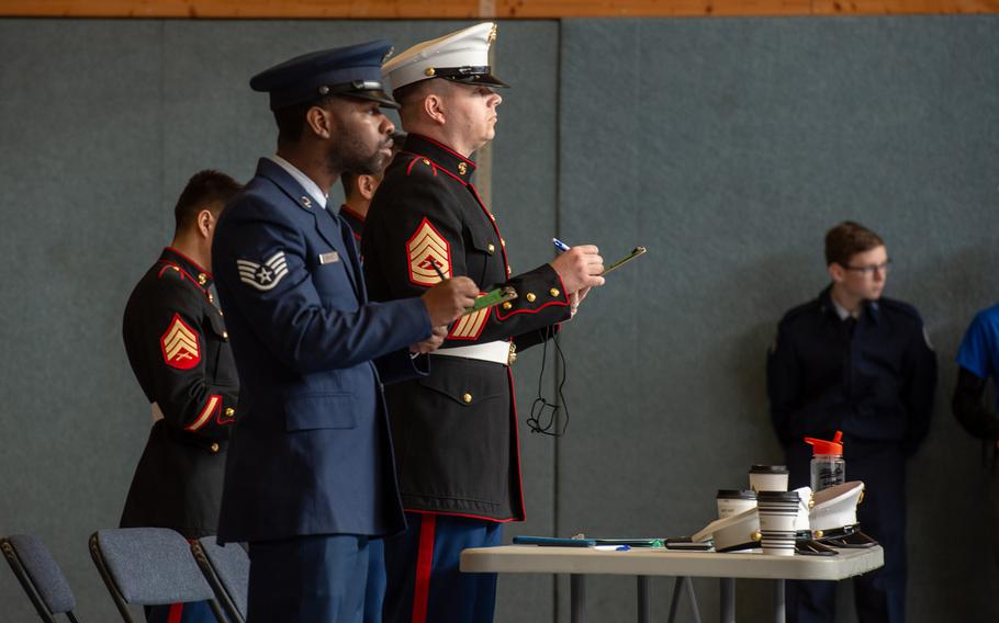 Staff Sgt. Garrett Rhodes and Gunnery Sgt. Matthew Nolan judge the rifle solo exhibition during the DODEA-Europe JROTC drill team championships at Ramstein, Germany, Saturday, March 2, 2019.