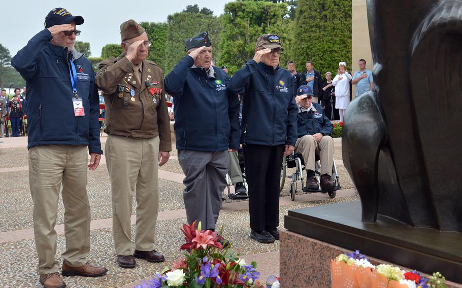 A group of World War II veterans salutes after laying a wreath at the foot of the ''Spirit of American Youth Rising from the Waves'' statue at Normandy American Cemetery at Colleville-sur-Mer, in June 2018.