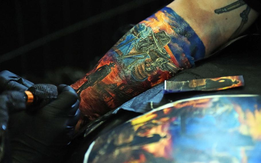 A cowboy-themed tattoo sleeve being worked on at the Grafenwoehr Tattoo Expo, in Grafenwoehr, Germany, Sunday, April 8, 2019.
