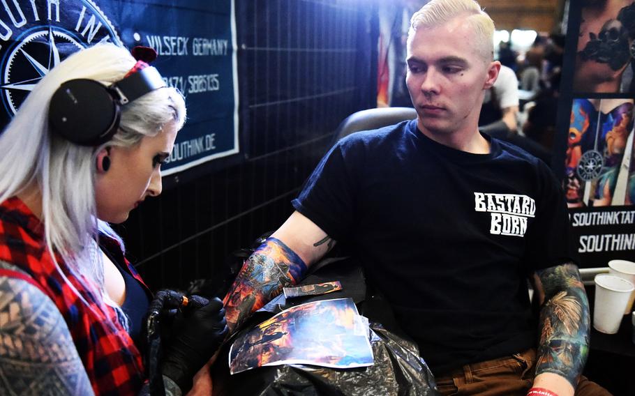 Lisa South, a tattoo artist, works on Pvt. Rodawald Gage's "cowboys and Indians" themed tattoos at the Grafenwoehr Tattoo Expo, in Grafenwoehr, Germany, Sunday, April 8, 2019. Gage is an infantryman with the Army's 2nd Cavalry Regiment.