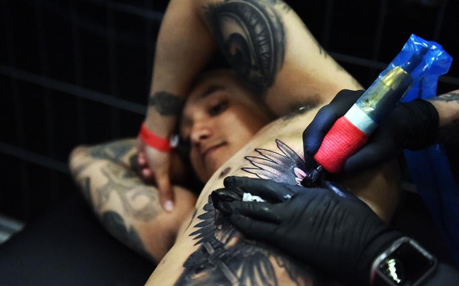 Spc. Erick Lorduy, a radio operator with the Army's 2nd Cavalry Regiment, gets an owl tattooed on his ribs at the Grafenwoehr Tattoo Expo, in Grafenwoehr, Germany, Sunday, April 8, 2019.