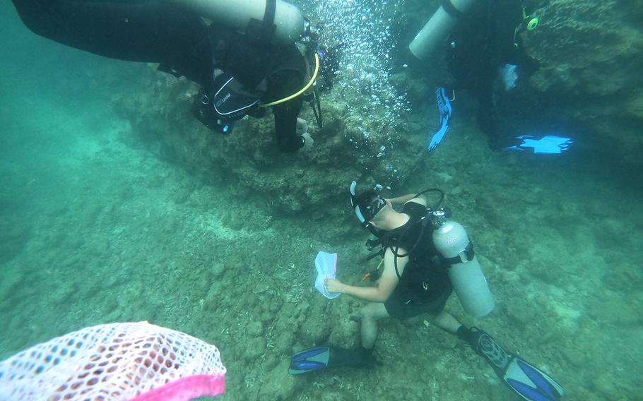 Volunteer divers search and collect trash from the ocean floor during a cleanup event hosted by Mermaid Island Diving and Project Aware in Chatan, Okinawa, Saturday, April 20, 2019.