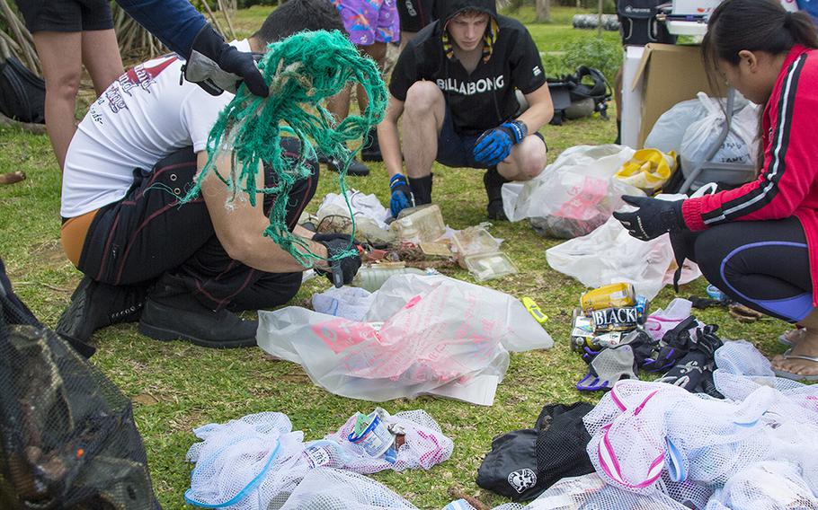 Volunteers sort garbage collected from the ocean during a cleanup event hosted by Mermaid Island Diving and Project Aware in Chatan, Okinawa, Saturday, April 20, 2019.