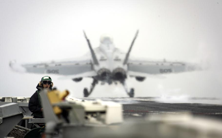 Seaman Kenneth Mathison, an airman, stands watch as an EA-18G Growler from the Electronic Attack Squadron 140 launches from the flight deck of the aircraft carrier USS Abraham Lincoln in the Mediterranean Sea, April 21, 2019.