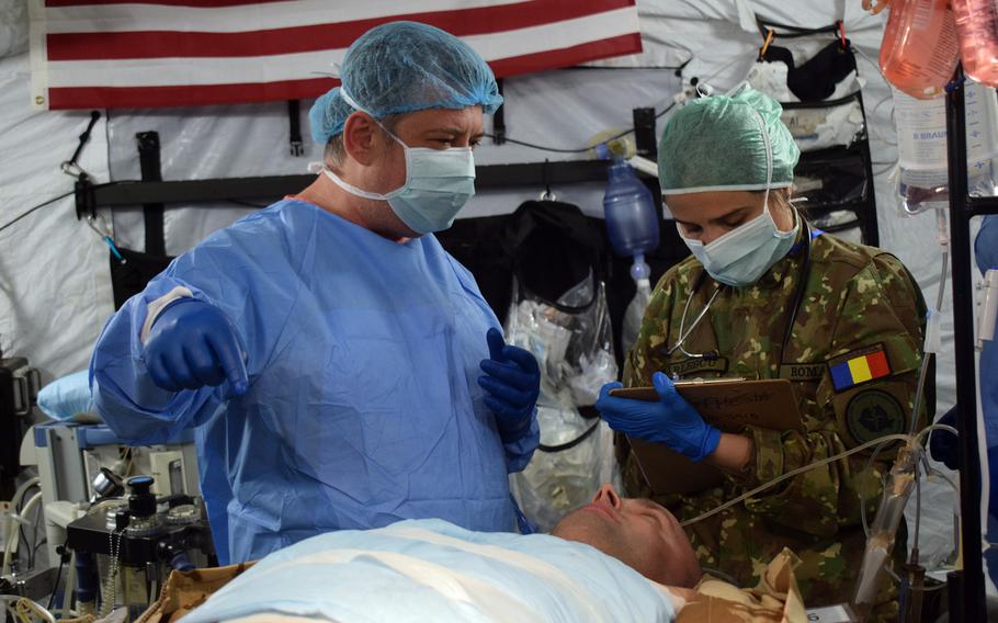 Dr. Bogdan Mihalache, general surgeon, Iasi Military Hospital, Romania, and 1st Lt. Roxana Oparlescu, participate in a multinational surgical exchange drill at the U.S. Air Force 86th Medical Group Role 2 field hospital at Cincu Military Base, Romania, on April 11, 2019.