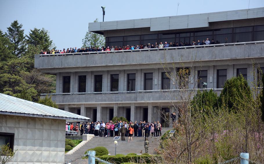 Tourists on the North Korean side of the Joint Security Area wave at reporters visiting the southern side of the truce village of Panmunjom, Wednesday, May 1, 2019.