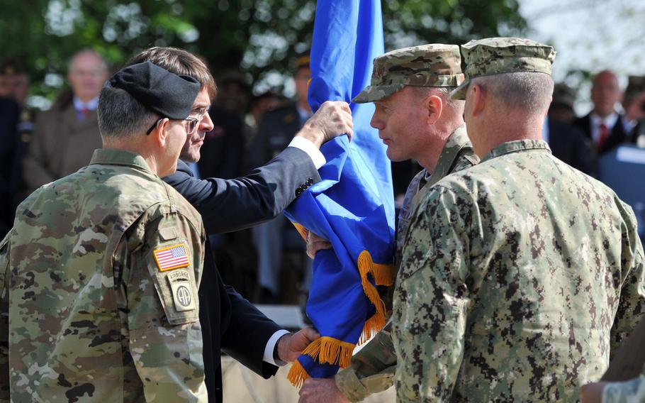 The outgoing commander of U.S. European Command, Army Gen. Curtis M. Scaparrotti, left, watches as Army Secretary Mark T. Esper passes the command's colors to incoming commander Air Force Gen. Tod. D. Wolters at Patch Barracks in Stuttgart, Germany, Thursday, May 2, 2019.