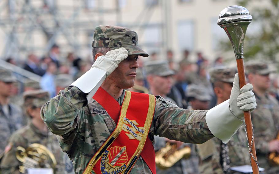 Sgt. 1st Class Andre Goncalves, the drum major for the joint U.S. Army Europe and U.S. Air Forces in Europe band at the U.S. European Command change of command ceremony salutes as distinguished visitors leave the parade field at Patch Barracks in Stuttgart, Germany, following the ceremony.
