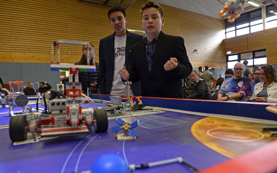 Team REV3NGERS members Alec Eschenlauer, left, and Daniel Olson look on as their autonomous robot successfully completes a mission during the robotics and music exhibition at Ramstein Middle School, Germany, May 9, 2019.