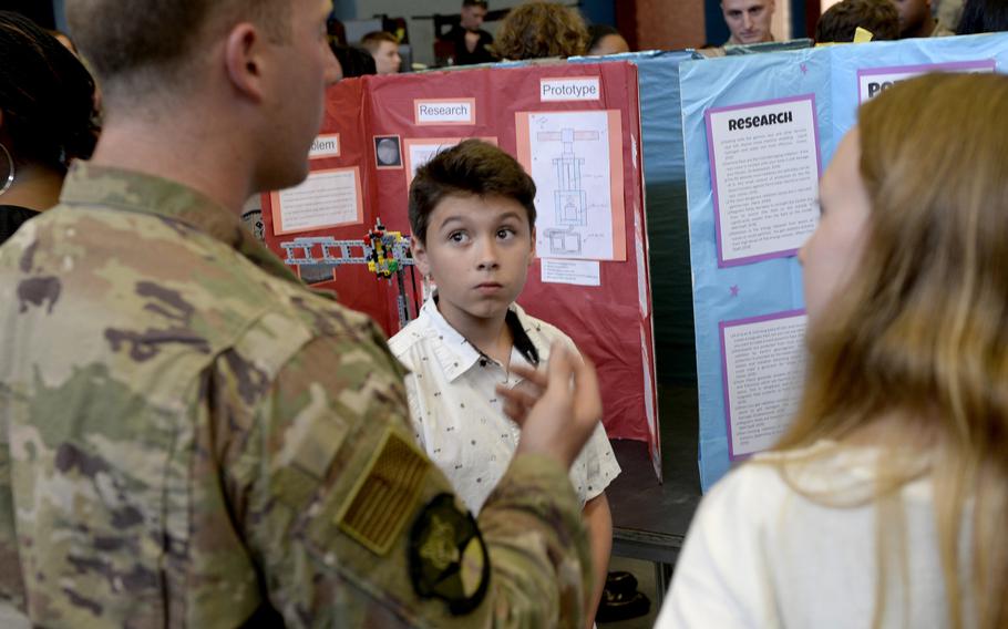 Xavian Santiago gets feedback as a 435th Contingency Response Group airman judges his team's research project during the robotics and music exhibition at Ramstein Middle School, Germany, May 9, 2019.
