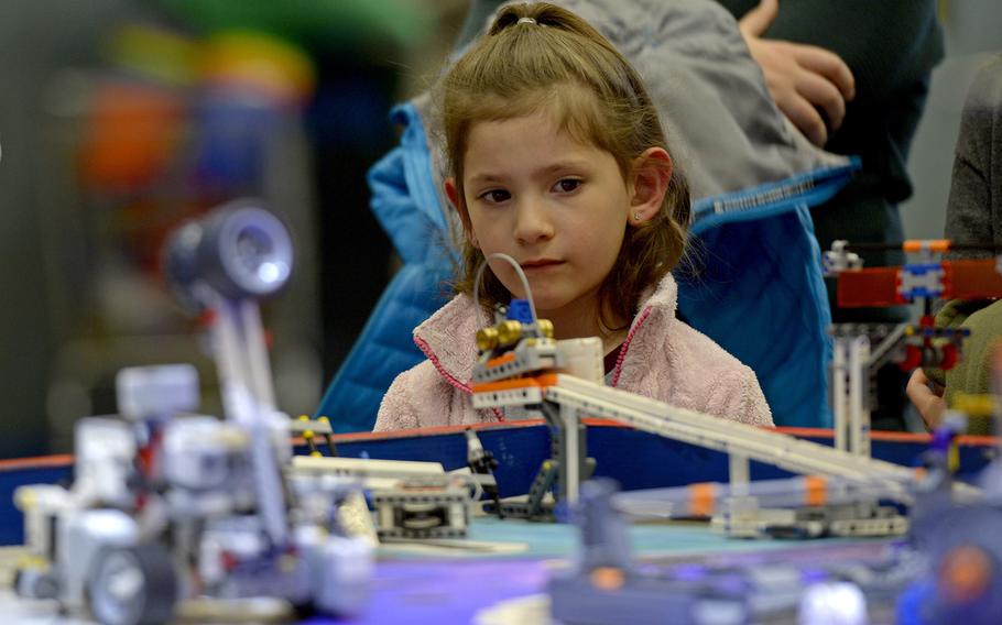 A young girl looks on as teams demonstrate their autonomous robots during the robotics and music exhibition at Ramstein Middle School, Germany, May 9, 2019.