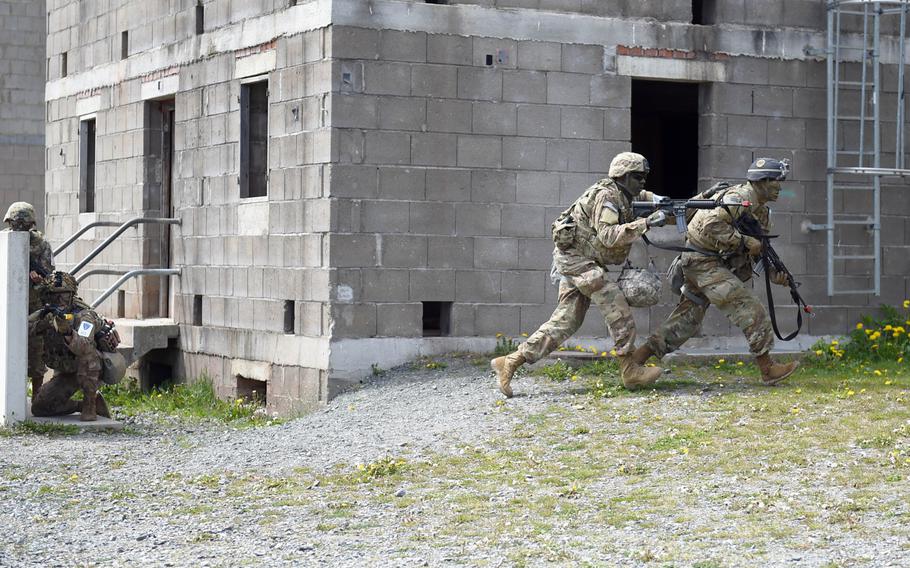 Soldiers competing in the U.S. Army Europe Best Warrior Competition rushing to a building at the urban combat training area at Grafenwoehr, Germany, Wednesday, May 8, 2019.