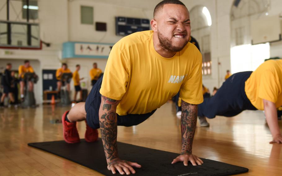 Petty Officer 2nd Class Alexander Love, assigned to the aircraft carrier USS Theodore Roosevelt, completes a pushup during the spring 2019 physical readiness test,  April 23, 2019. The Navy has issued guidelines to halt physical training of sailors who show unusual distress and let them make up the training another day.