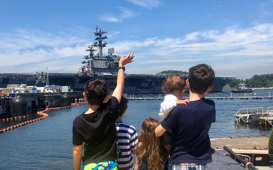 The children of Lt. Cmdr. Daniel Supple – James, 9; Charles, 7; Juliet, 4; Alexander, 1; and William, 12 – watch as the USS Ronald Reagan departs Yokosuka Naval Base, Japan, Wednesday, May 22, 2019.