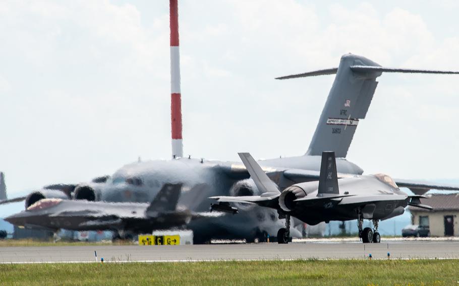 Two F-35 Lightning IIs, part of  the European theater security package, taxi in front of a C-17 before takeoff from Spangdahlem Air Base, Germany, June 18, 2019.