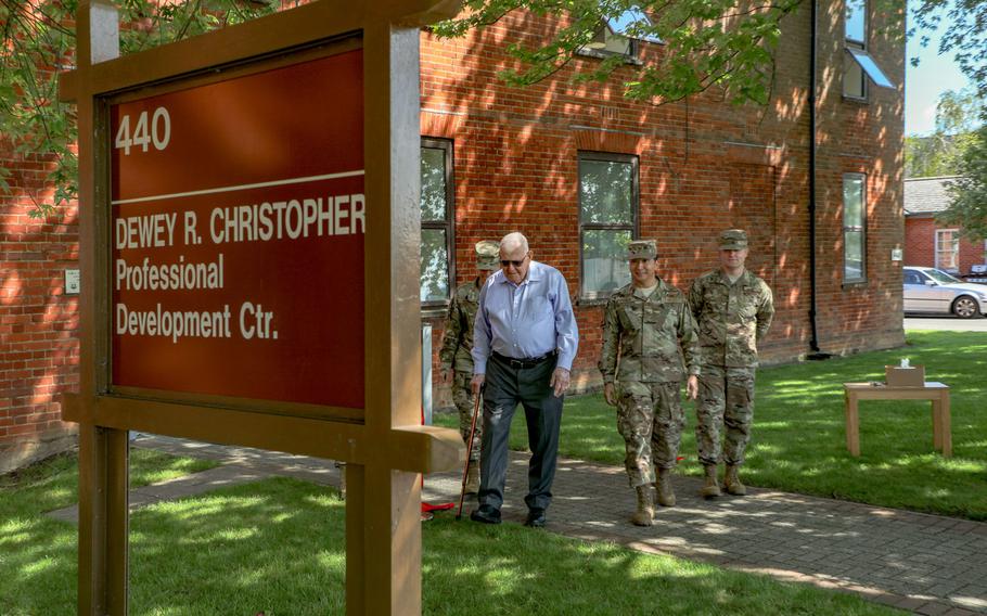 Dewey R. Christopher, center, walks toward the new sign, bearing his name, for the Professional Development Center at RAF Mildenhall with Chief Master Sgt. Kristina L. Rogers, left, Col. S. Troy Pananon, second from right and Master Sgt. Curtis Brown, right, on  June 21, 2019.