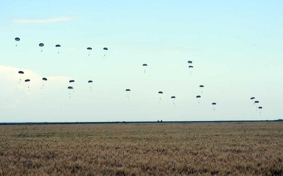 German and Dutch paratroopers jump over a wheat field to take part in Exercise Swift Response, in Romania, Thursday, June 13, 2019.