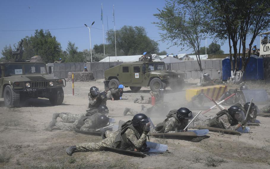 Soldiers with the Kazakh Ground Forces peacekeeping battalion lie flat on the ground as a soldier fires his weapon into the air to scare rioters as part of a training exercise between American, British and Kazakh troops June 24, 2019. The Steppe Eagle exercise at the Chilikemer Training Area outside of Almaty trained Kazakh troops before their United Nations mission to Lebanon in the fall.