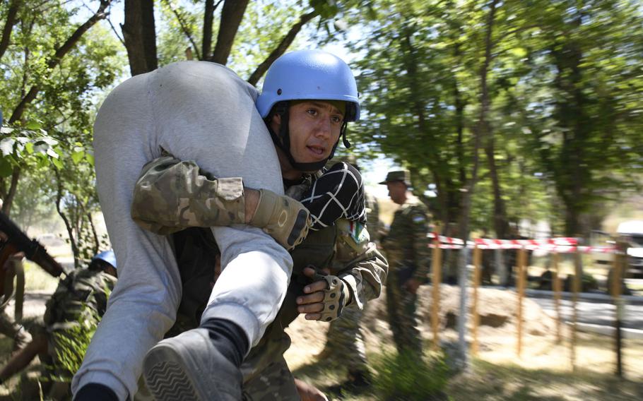 A soldier from Tajikistan carries a civilian injured by shrapnel as part of a training exercise between American, British, Tajik and Kazakh troops June 25, 2019. The Steppe Eagle exercise at the Chilikemer Training Area outside Almaty brought together troops for training on peacekeeping and stability operations.