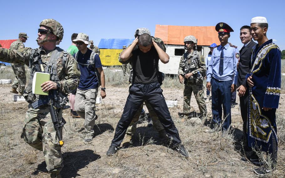 U.S. Army soldiers from 1st Battalion, 158th Infantry Regiment search an actor posing as a villager suspected of hiding a weapons cache, during Exercise Steppe Eagle at the Chilikemer training area in Kazakhstan on June 23, 2019. Steppe Eagle brought together Western and Central Asian troops for training on peacekeeping and stability operations, and included gender-focused training.