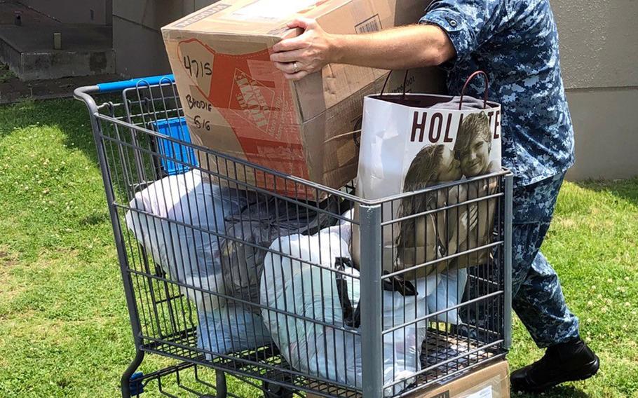 Cmdr. Robert Brodie, executive officer of Fleet Coordinating Group at Yokosuka Naval Base, Japan, unloads a basket of donations for earthquake and tsunami victims, Tuesday, June 25, 2019.