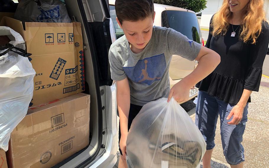 Ben Krug loads a sack of donated clothing into a van headed to help Japan earthqauke and tsunami victims, Tuesday, June 25, 2019, at Yokosuka Naval Base, Japan.
