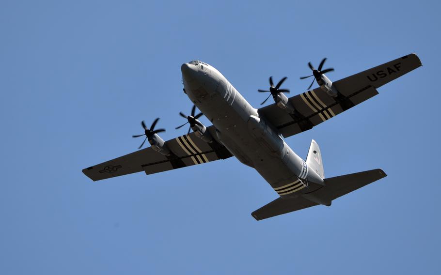 A C-130J Hercules from Ramstein Air Base's 37th Airlift Squadron, sporting World War II-style invasion stripes, carries members of the base's 435th Contingency Response Group for a parachute jump onto the base. The unit had a rare opportunity for a "home game," as operational tempo at Ramstein usually doesn't allow a jump on the base.