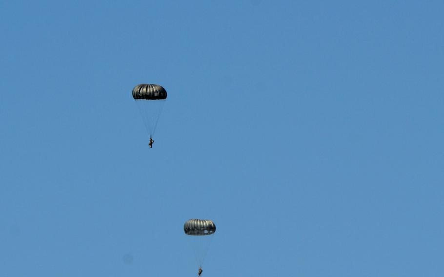 After jumping out of a C-130J from Ramstein Air Base's 37th Airlift Squadron, paratroopers from the base's 435th Contingency Response Group float through a blue, summer sky back down to the base.