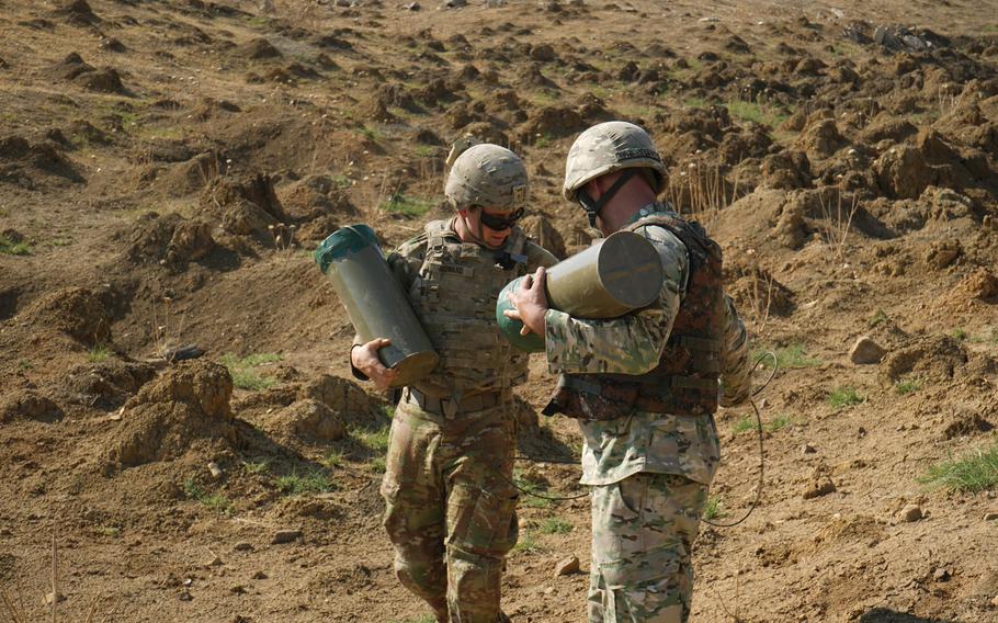 A Georgian and a U.S. soldier, assigned to the Regimental Engineer Squadron, 2nd Cavalry Regiment, carry casings for C-4 explosives during Agile Spirit 19 near Tbilisi, Georgia, July 30, 2019.